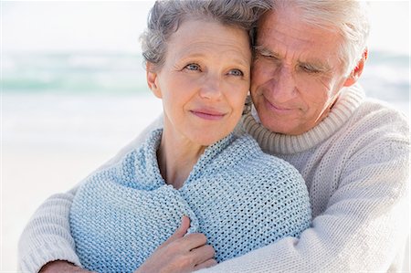 Active senior man embracing his wife from behind on the beach Stock Photo - Premium Royalty-Free, Code: 6108-08663053