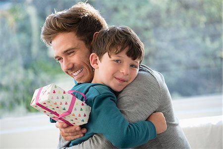 father with two sons not girls - Loving father and son hugging with birthday gift Stock Photo - Premium Royalty-Free, Code: 6108-08663216