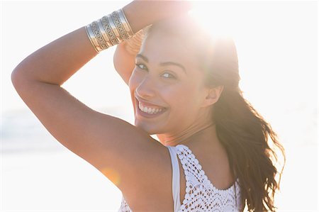Smiling young woman posing on the beach Stock Photo - Premium Royalty-Free, Code: 6108-08663353