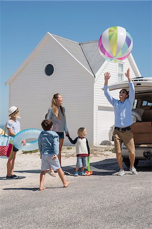 Happy young family packing car with beach gears for vacation Stock Photo - Premium Royalty-Free, Code: 6108-08663325