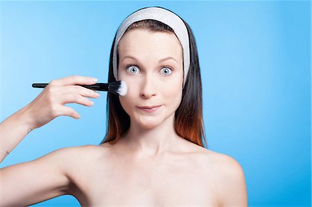simsearch:6108-08637407,k - Humorous portrait of a woman using a makeup brush on face Stock Photo - Premium Royalty-Free, Code: 6108-08637251