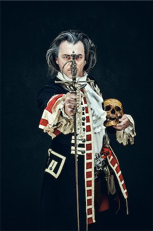 Officer in uniform "dragons", presents his sword facing the camera, a skull under the elbow Foto de stock - Sin royalties Premium, Código: 6108-08637272