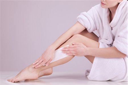 Young woman plucking her legs Stock Photo - Premium Royalty-Free, Code: 6108-08637304