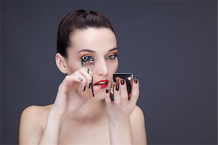 simsearch:6108-08637407,k - Portrait of a young woman using eyelash curler Stock Photo - Premium Royalty-Free, Code: 6108-08637321
