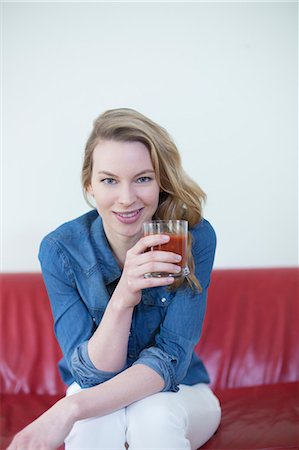 relieved - Woman enjoying a drink on the couch Stock Photo - Premium Royalty-Free, Code: 6108-08943542