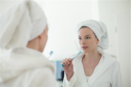 simsearch:400-04151137,k - Woman in bathrobe brushing her teeth in front of the mirror Photographie de stock - Premium Libres de Droits, Code: 6108-08943569