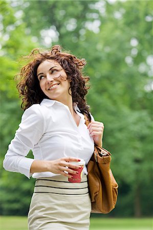 Businesswoman with coffee relaxing in a park Stock Photo - Premium Royalty-Free, Code: 6108-08909000