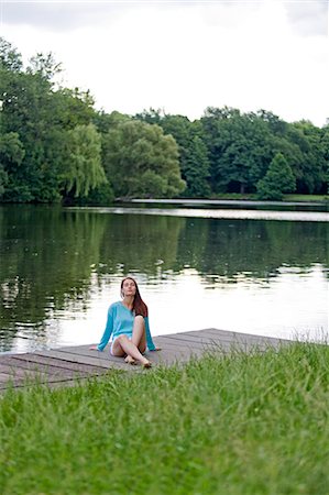 Woman relaxing on pier by a lake Stock Photo - Premium Royalty-Free, Code: 6108-08909270