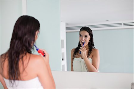 simsearch:400-04151137,k - Brunette woman brushing her teeth in front of the mirror Photographie de stock - Premium Libres de Droits, Code: 6108-08909583
