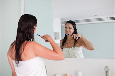 simsearch:400-04151137,k - Brunette woman brushing her teeth in front of the mirror Photographie de stock - Premium Libres de Droits, Code: 6108-08909580