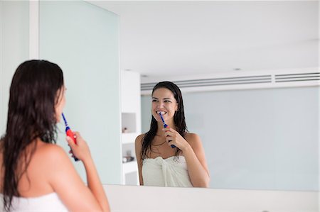 simsearch:400-04151137,k - Brunette woman brushing her teeth in front of the mirror Photographie de stock - Premium Libres de Droits, Code: 6108-08909582