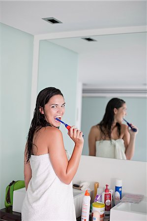 simsearch:400-04151137,k - Brunette woman brushing her teeth in front of the mirror Photographie de stock - Premium Libres de Droits, Code: 6108-08909584