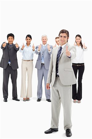 Multicultural business team with their thumbs-up focus on a man in foreground Stock Photo - Premium Royalty-Free, Code: 6109-06002674