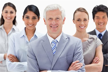simsearch:6109-06002816,k - Close-up of a multicultural business team smiling behind their boss against white background Stock Photo - Premium Royalty-Free, Code: 6109-06002709