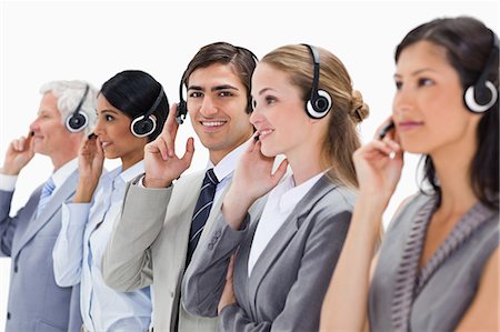 simsearch:6109-06002816,k - Smiling professionals in suits listening with headsets against white background Stock Photo - Premium Royalty-Free, Code: 6109-06002818