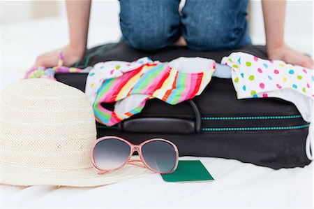 full picture of a person - A woman kneeling down on her suitcase, trying to make everything fit in it. Stock Photo - Premium Royalty-Free, Code: 6109-06003065