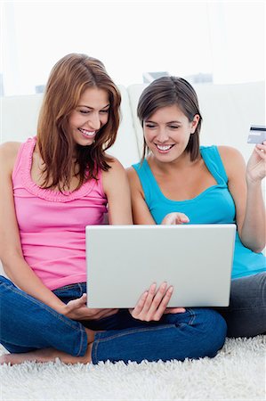 showing - Heureuse jeunes femmes s'asseoir avec un ordinateur portable lors de vos achats sur internet Photographie de stock - Premium Libres de Droits, Code: 6109-06003345