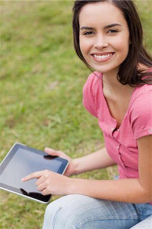 personal computer - Happy young girl looking at the camera while using her tablet computer in a park Stock Photo - Premium Royalty-Free, Code: 6109-06003431