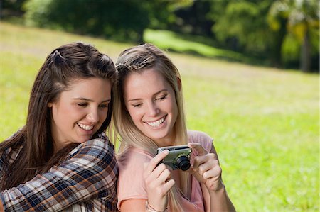 Young happy women looking at a digital camera in the countryside Stock Photo - Premium Royalty-Free, Code: 6109-06003548