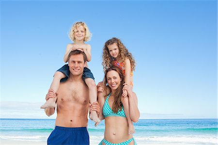 simsearch:6109-06003758,k - Young parents with their children on their shoulders on the beach Stock Photo - Premium Royalty-Free, Code: 6109-06003642