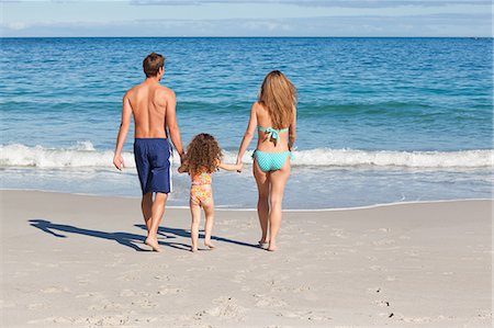 simsearch:6109-06003758,k - Young family on the beach walking towards the sea Stock Photo - Premium Royalty-Free, Code: 6109-06003609