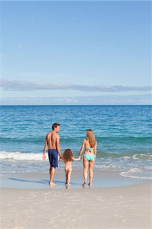 simsearch:6109-06003758,k - Young family walking towards the sea on the beach Stock Photo - Premium Royalty-Free, Code: 6109-06003610