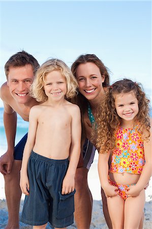 picture of boy and girl in swimsuits - Happy young family spending their time on the beach Stock Photo - Premium Royalty-Free, Code: 6109-06003627
