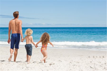simsearch:6109-06003758,k - Young father walking with his children on the beach Stock Photo - Premium Royalty-Free, Code: 6109-06003754