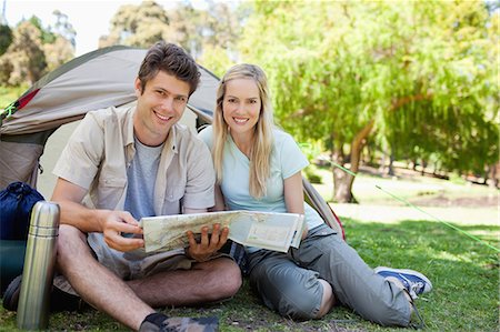 simsearch:6109-06003893,k - A smiling couple camp together while they hold a map and look into the camera Stock Photo - Premium Royalty-Free, Code: 6109-06003876