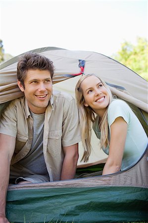 simsearch:6109-06003893,k - A smiling couple are almost fully in the tent as they look up to the sky Stock Photo - Premium Royalty-Free, Code: 6109-06003882