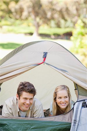 simsearch:6109-06003893,k - The couple lying down in the tent together are looking at something to the side and smiling Stock Photo - Premium Royalty-Free, Code: 6109-06003887
