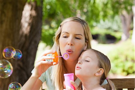 A close up shot of a mother and her daughter blowing bubbles together Stock Photo - Premium Royalty-Free, Code: 6109-06003961
