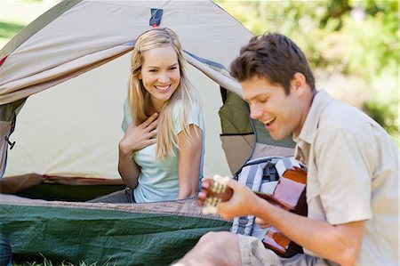 simsearch:6109-06003893,k - A woman in the tent smiles as she listens to her lovers playing and singing Stock Photo - Premium Royalty-Free, Code: 6109-06003900
