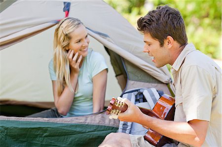 simsearch:6109-06003893,k - A man plays the guitar and sings for his girlfriend while she smiles and looks to the side Stock Photo - Premium Royalty-Free, Code: 6109-06003904