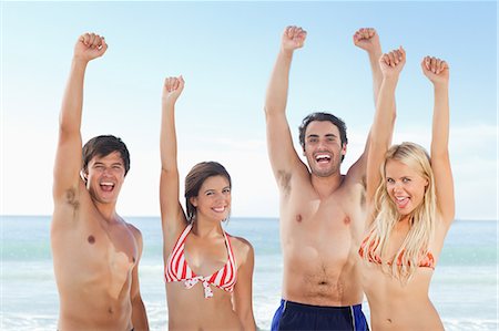simsearch:6109-06004195,k - Four people together at the beach celebrating in their swimming clothes. Stock Photo - Premium Royalty-Free, Code: 6109-06004269