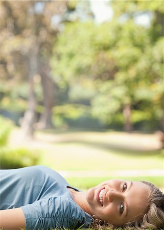 simsearch:6109-06003893,k - Side view of a smiling young woman on the lawn Stock Photo - Premium Royalty-Free, Code: 6109-06004360
