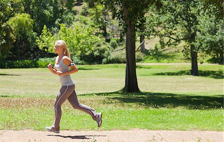 Side view of a jogging young woman Stock Photo - Premium Royalty-Free, Code: 6109-06004310