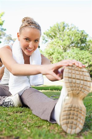 fitness in park - Smiling young sportswoman on the lawn doing her stretches Stock Photo - Premium Royalty-Free, Code: 6109-06004556