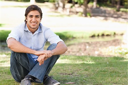 simsearch:6109-06003893,k - Smiling young man sitting on the lawn Stock Photo - Premium Royalty-Free, Code: 6109-06004502