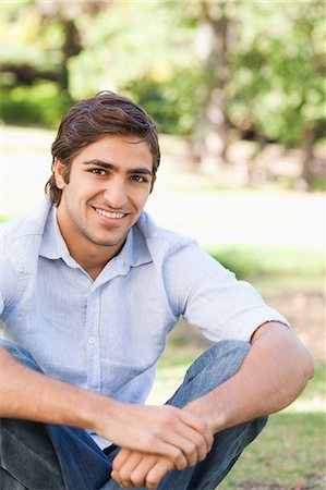 simsearch:6109-06003893,k - Smiling young man sitting in the park Stock Photo - Premium Royalty-Free, Code: 6109-06004504
