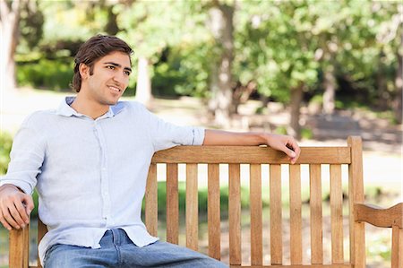 simsearch:6109-06003893,k - Young man sitting on a bench in the park Stock Photo - Premium Royalty-Free, Code: 6109-06004513