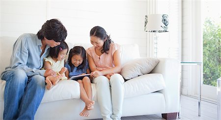 ethnicity - A cheerful family using a tablet while they smile and sit on the couch Stock Photo - Premium Royalty-Free, Code: 6109-06004870