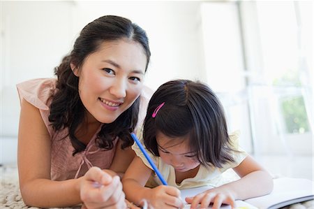 pretty draw - La fille continue à colorer son livre tandis que sa mère lève les yeux et sourire Photographie de stock - Premium Libres de Droits, Code: 6109-06004905