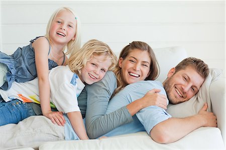 The smiling family all lie on one another across the couch Stock Photo - Premium Royalty-Free, Code: 6109-06005068