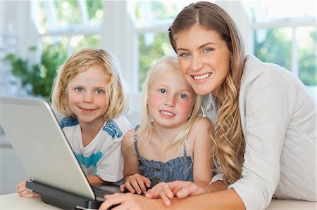 family computer kitchen - Smiling children with their mother use the laptop in the living room Stock Photo - Premium Royalty-Free, Code: 6109-06005158