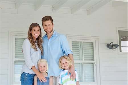 father hugging his son and daughter - A smiling happy family stand together on the porch Stock Photo - Premium Royalty-Free, Code: 6109-06005184