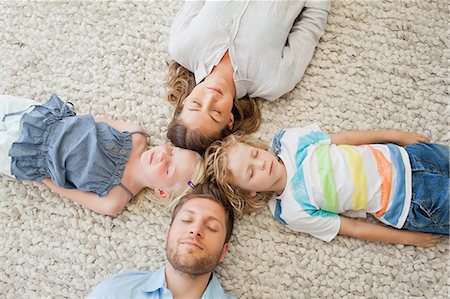 The family asleep on the floor together as there heads all touch Stock Photo - Premium Royalty-Free, Code: 6109-06005114