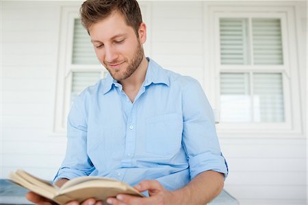 Un homme avec un bon livre dans ses mains la lecture tant qu'il est assis sur le porche Photographie de stock - Premium Libres de Droits, Code: 6109-06005221