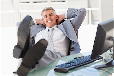 Happy boss with feet on his desk in a bright office Stock Photo - Premium Royalty-Free, Code: 6109-06005328