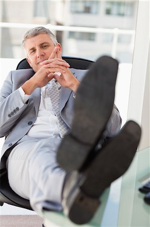 Businessman with feet on his desk  in a bright office Stock Photo - Premium Royalty-Free, Code: 6109-06005329
